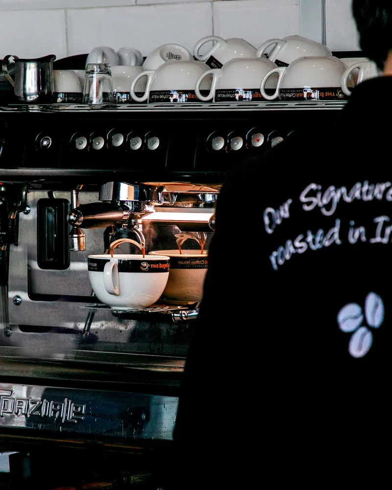 Barista making coffee with an espresso machine in a Baku café.