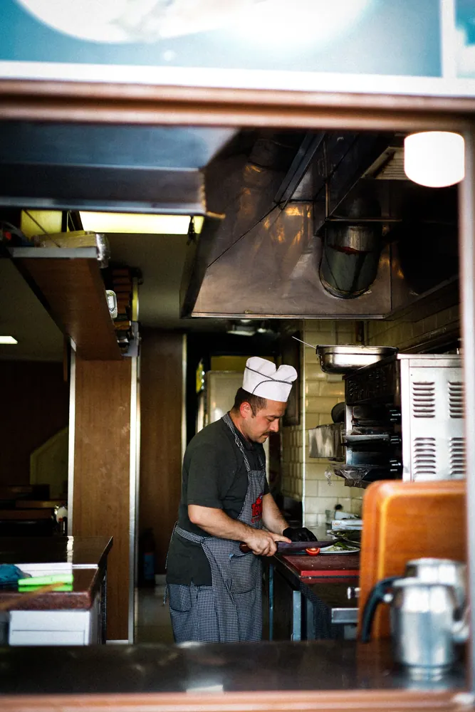 Chef in a cozy kitchen preparing food, showcasing culinary expertise.