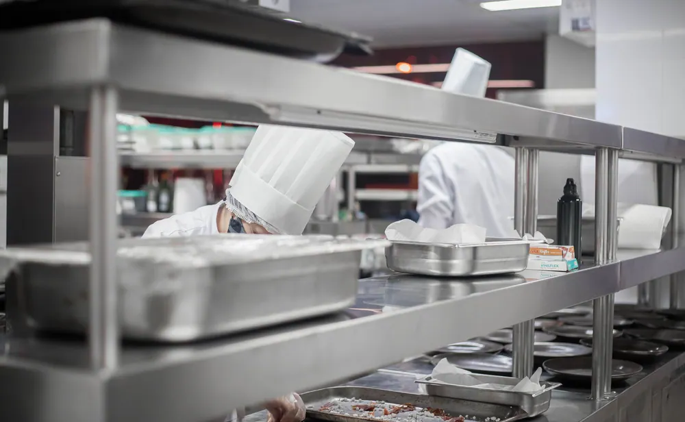 Chefs working diligently in a modern stainless steel kitchen, preparing delicious dishes.