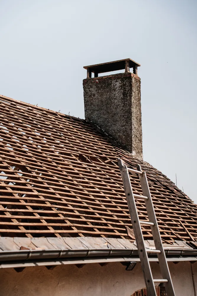 A traditional rooftop under renovation with visible chimney and ladder.